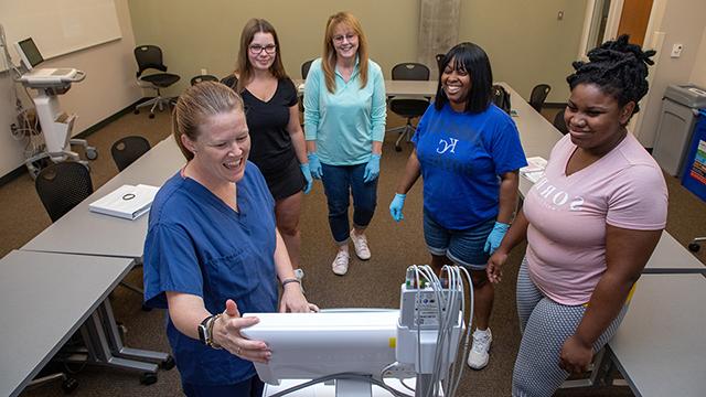 Nursing students learning about an ECG machine